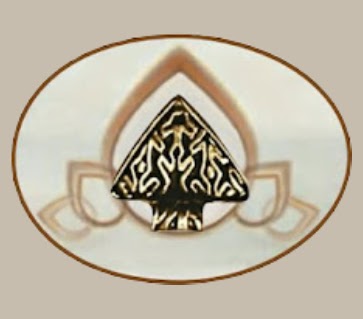 image shows a gold-colored ring on a white plate. The ring has an intricate design on it